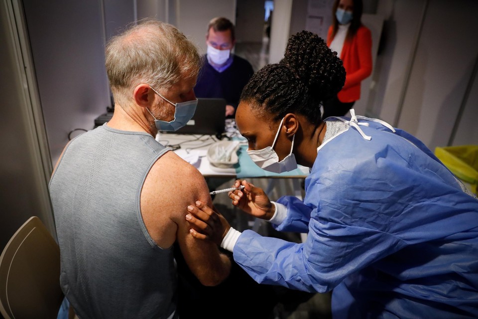 Een man in Brussel krijgt na twee eerdere vaccins zijn eerste boosterprik. 