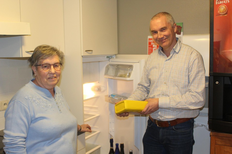Schepen Frank Vandebeek bij bewoonster Maria Geybels van serviceflats de Brug, met een proefexemplaar van de ‘gele doos’ 