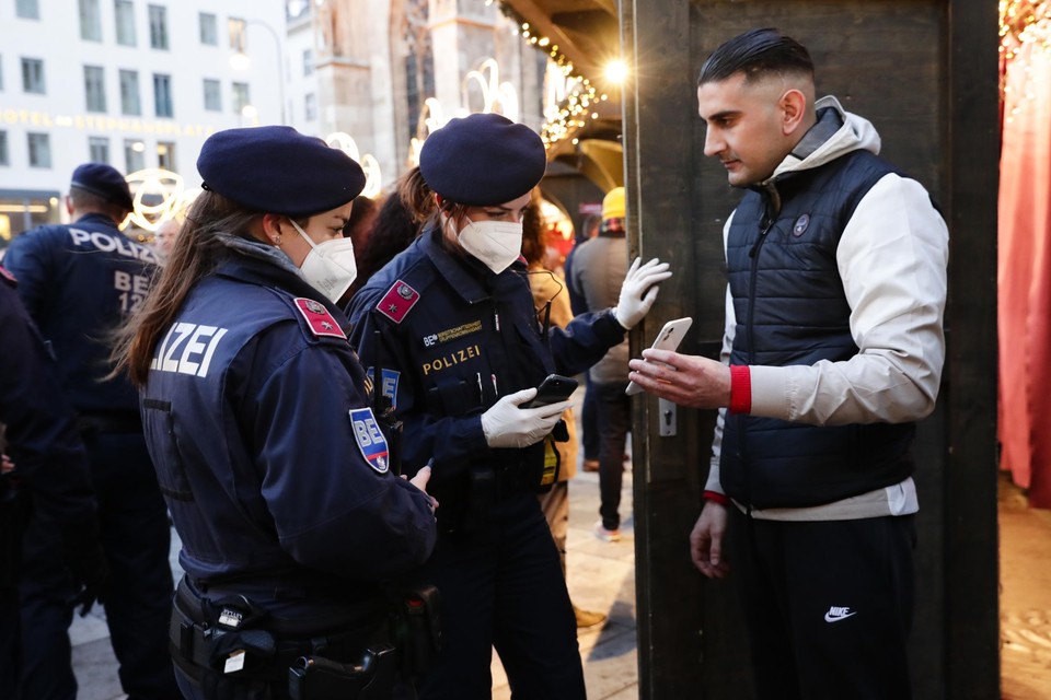 Oostenrijkse politieagenten controleren vaccinatiebewijzen op een kerstmarkt in Wenen. 