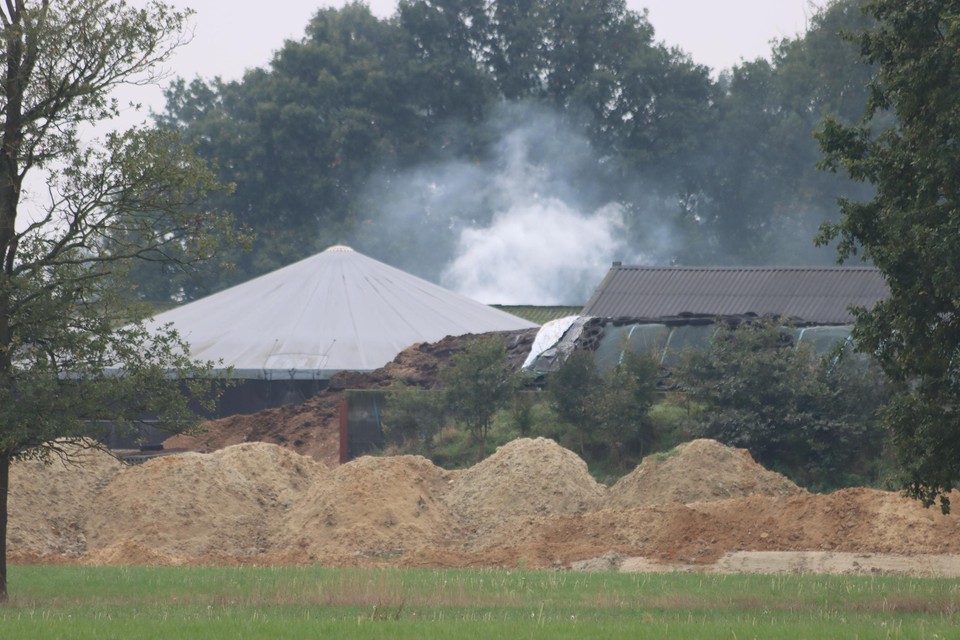 De rookpluim van de hooibrand hing boven de loodsen van het landbouwbedrijf. 