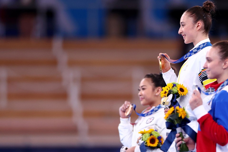Sunisa Lee (l.) behaalde aan de brug met ongelijke leggers brons, Nina Derwael (midden) werd olympisch kampioene. Lee is wel regerende olympisch kampioene allroundturnen. 