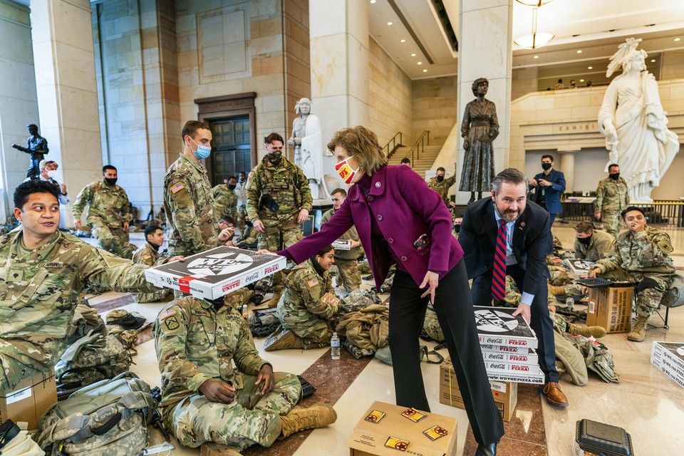 Het Capitool lijkt wel een versterkte burcht, vol manschappen van de National Guard. Met een stapel pizza’s steken de Republikeinen Vicky Hartzler en Michael Waltz hen een hart onder de riem.  
