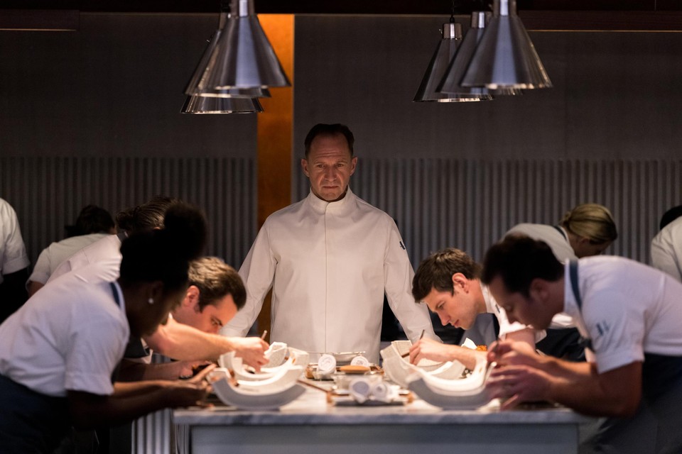 Ralph Fiennes (midden) als sinistere chef die in ‘The Menu’ zijn gasten het gastronomisch festijn van hun leven serveert. 
