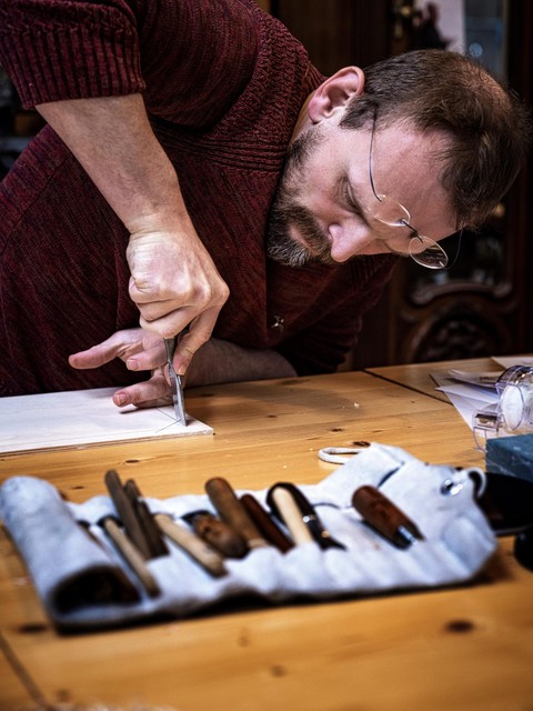 Vladimir Ivaneanu aan het werk aan een houtsnede.