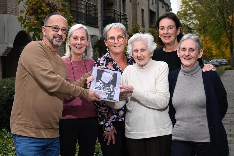 Auteur Mark Dreesen overhandigt het eerste exemplaar aan Sybille De Bilde-Dreessen, geflankeerd door haar dochters Daisy, Anita, Caroline en Brigitte. 