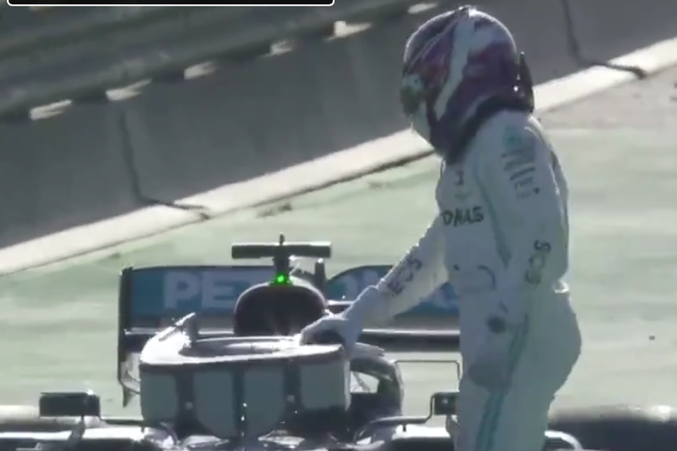 Lewis Hamilton naast zijn Mercedes F1-bolide die stil kwam te staan