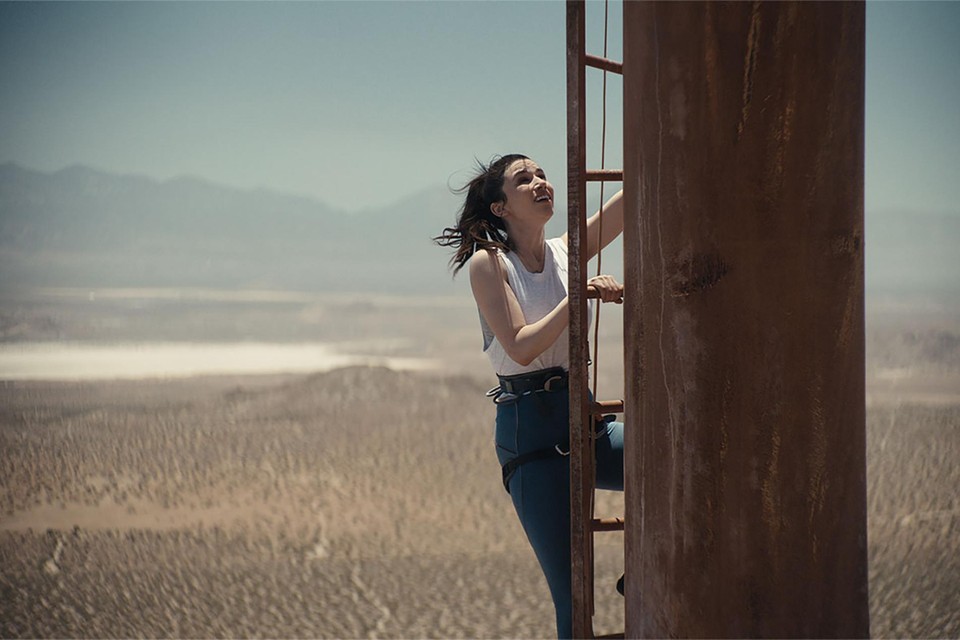 Twee vrouwen beklimmen in de woestijn een enorme radiomast die zo aangetast is door roest dat hun daad op een gecamoufleerde vorm van zelfmoord lijkt.  