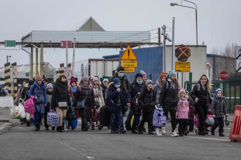 Oekraïense vluchtelingen steken de Poolse grens over in Korczowa. Volgens cijfers van de VN hebben al 875.000 mensen het land verlaten.  