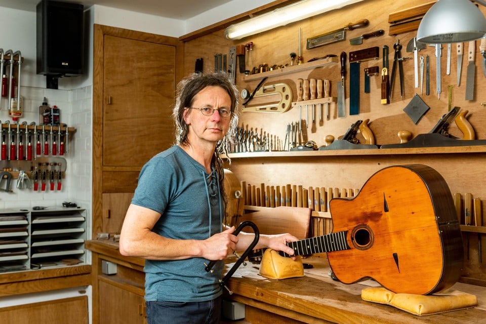 Gitaarbouwer Adam Berten met op zijn werkbank een van de gitaren die het merk Selmer speciaal voor Django Reinhardt bouwde. 