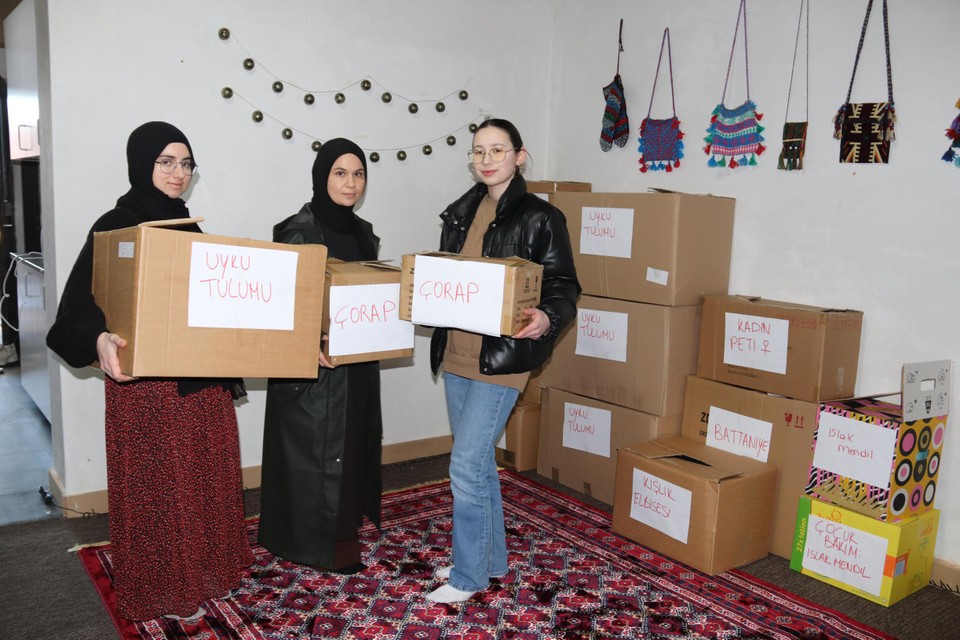 Sultan Teker (midden) helpt mee goederen verzamelen en verpakken voor Turkije. Ze verloor zelf drie familieleden door de aardbeving.