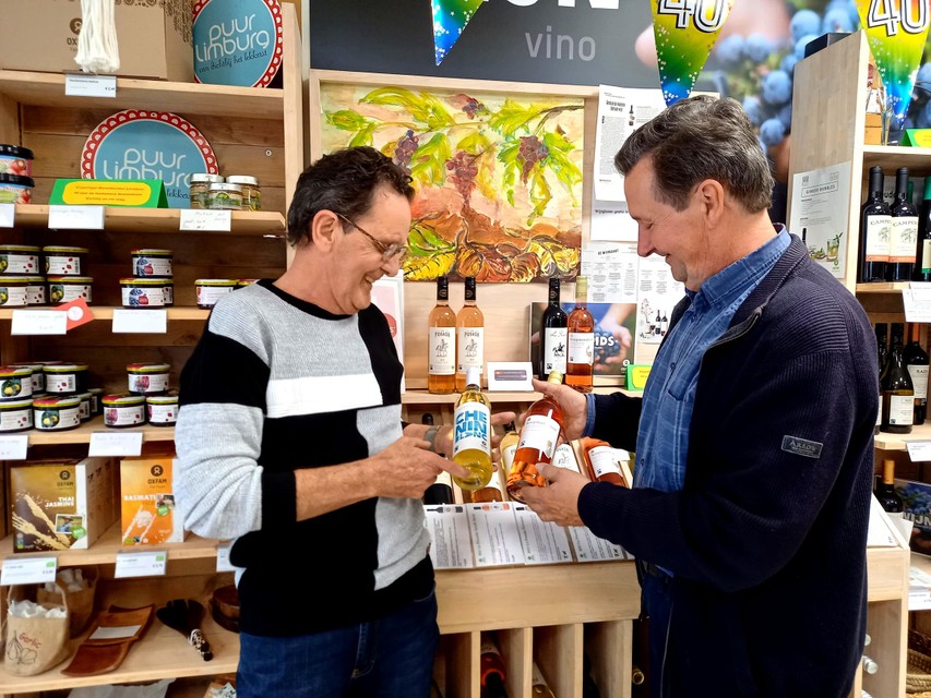 Raymond Hoeven en Eric Bijnens bij het assortiment wijnen in de Wereldwinkel in Lanaken 