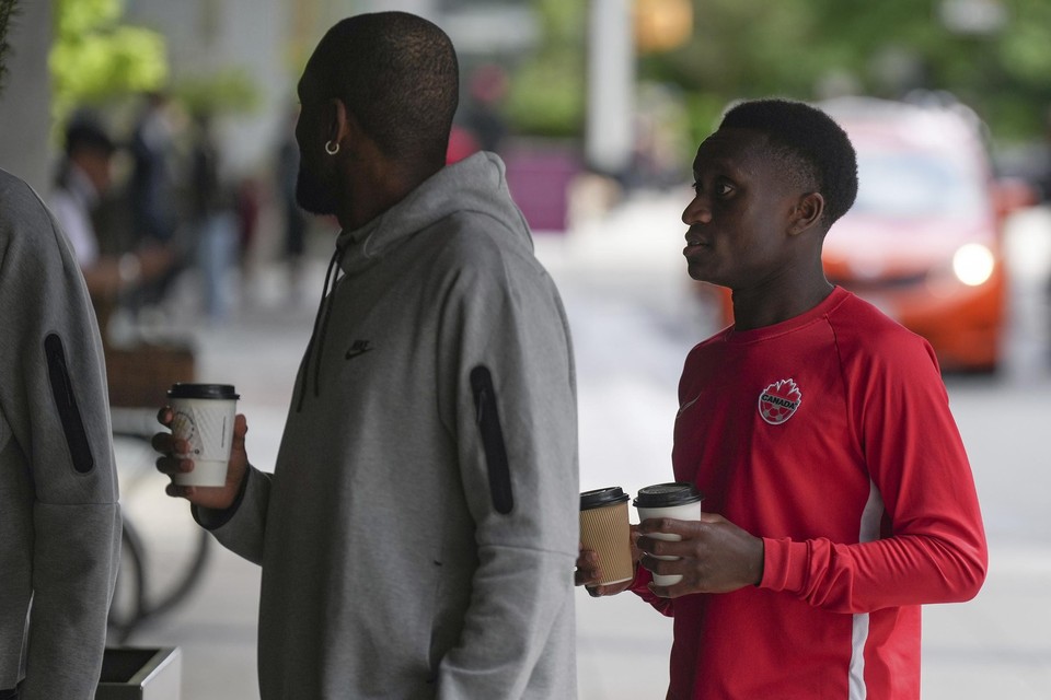 Canadees international Richie Laryea (rechts) is met zijn ploegmaats buiten het hotel een koffie gaan halen tijdens de stakingsactie.   
