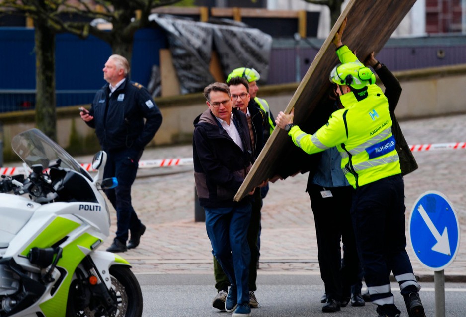 Voormalig minister en CEO van de Deense Kamer van Koophandel Brian Mikkelsen sleept een schilderij mee naar buiten.