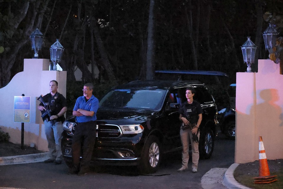 Gewapende FBI-agenten bewaken de ingang van Mar-a-Lago tijdens de huiszoeking.  