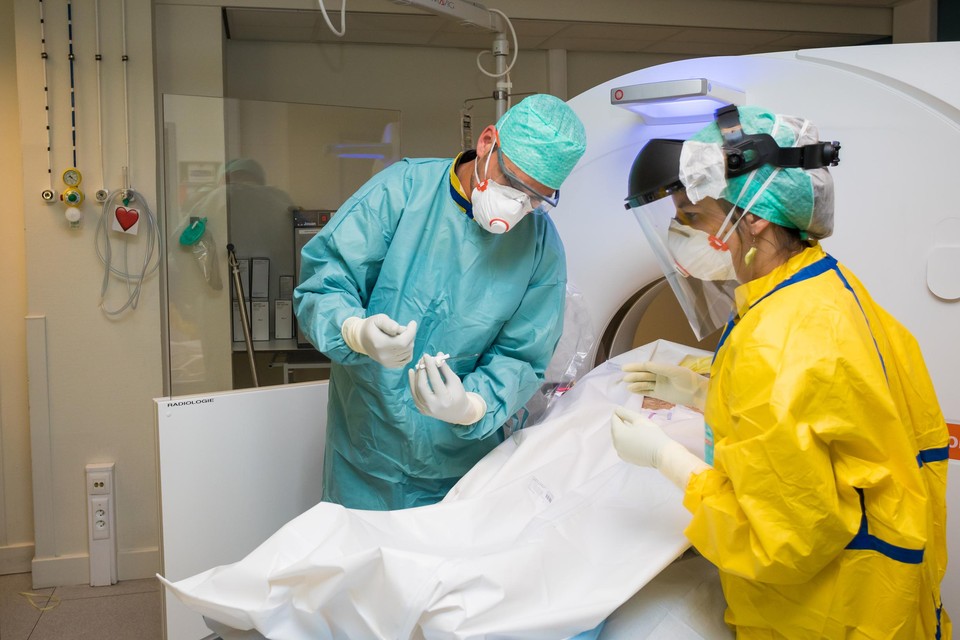 Dr. Jan Vanrusselt (links) neemt met een biopsienaald een staal bij een patiënt die in Jessa is overleden aan Covid-19. 