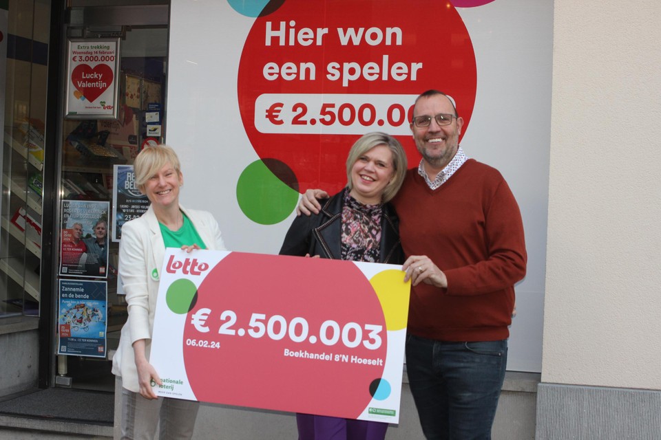Lotto-woordvoerster Liliane Goor overhandigt een symbolische cheque aan Inge Brands en Gunter Philtjens, uitbaters van boekhandel Achten.
