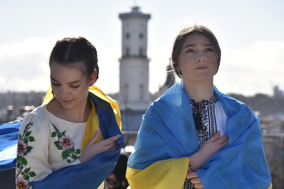 Twee meisjes poseren met Oekraïense vlag tijdens een patriottische mars in Lviv. 
