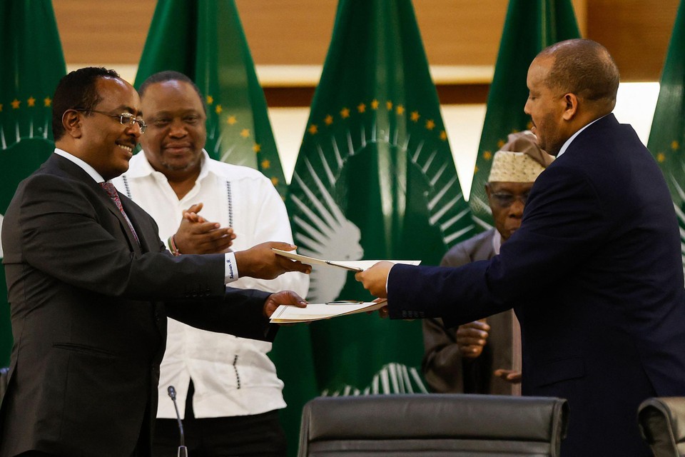 Redwan Hussien Rameto (links), vertegenwoordiger van de Ethiopische regering, en Getachew Reda (rechts), van het Tigray People’s Liberation Front, wisselen documenten uit nadat ze een vredesakkoord ondertekenden. 