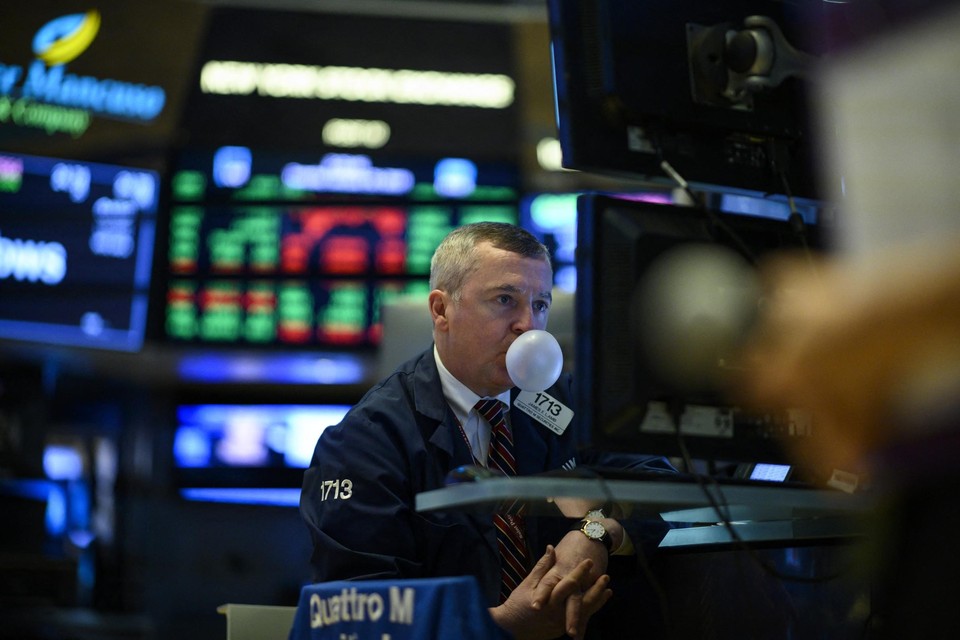 Een trader van de New York Stock Exchange blaast een bel van kauwgum. 