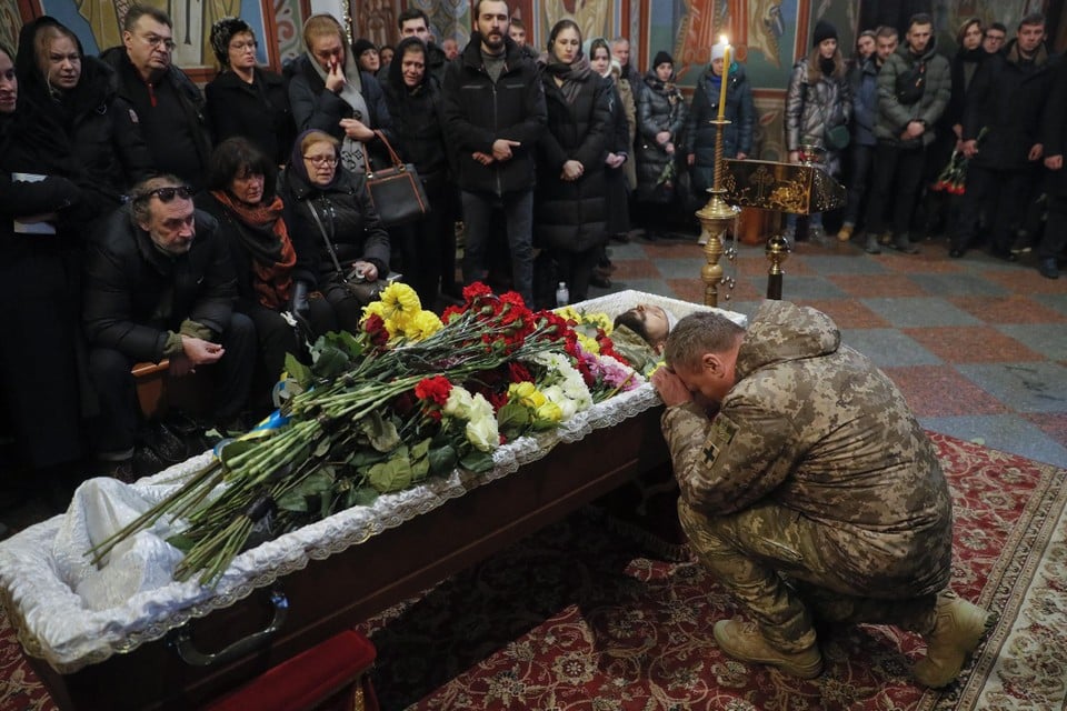 Een Oekraïense soldaat treurt bij de kist van een strijdmakker in Kiev. 