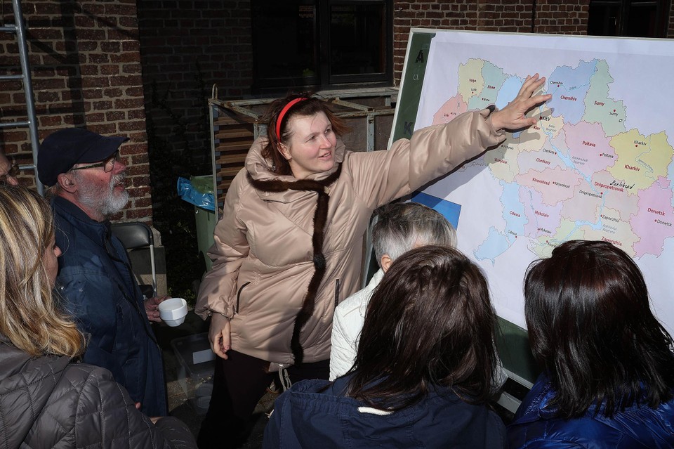 Een Oekraïense vrouw toont op een kaart waar ze vandaan komt. 