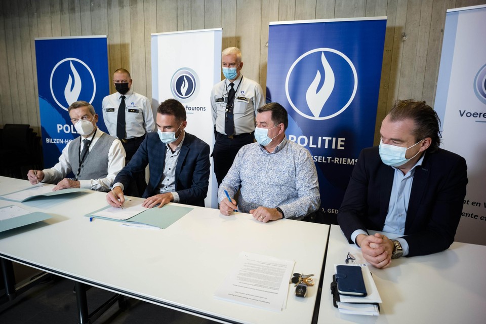 Vier burgemeesters, vlnr. Johan Sauwens, Joris Gaens, Werner Raskin en Mark Vos, tekenen het associatieprotocol tussen hun politiezones. Korpschefs Alain Stas (Voeren) en Dirk Claes (Bilzen-Hoeselt-Riemst) kijken goedkeurend toe. 