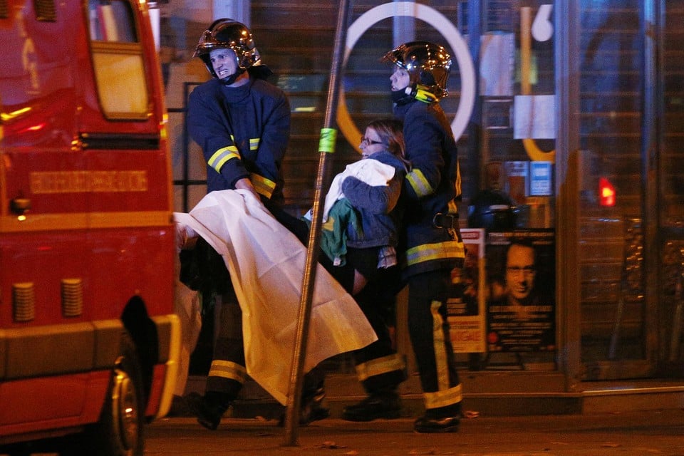 Hulpdiensten dragen een gewonde vrouw weg die de aanslag op de Bataclan heeft overleefd. 