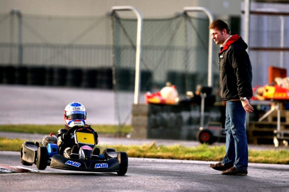 Vader Jos bekijkt in 2005 op het circuit in Genk met strakke blik de verrichtingen van Max in zijn kart.  