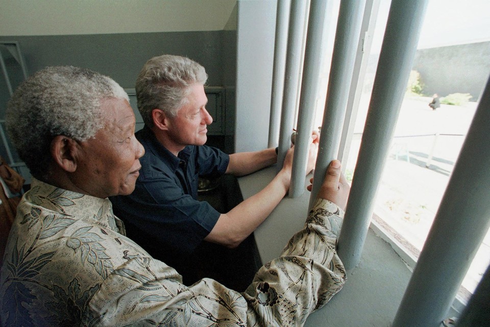 Nelson Mandela in zijn cel op Robbeneiland, bij een bezoek met de Amerikaanse president Bill Clinton in 1998.  