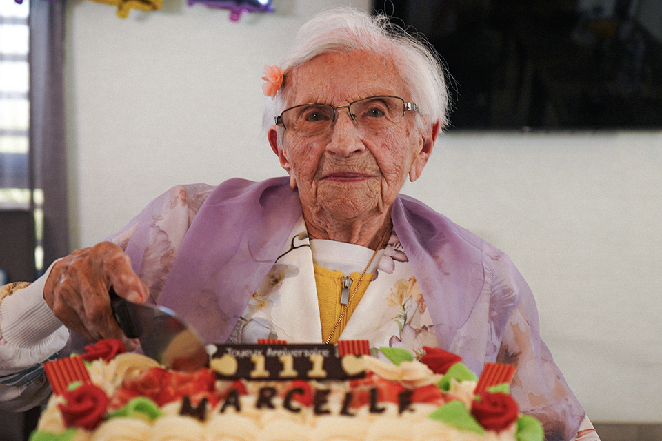 Marcelle Levaz snijdt de taart aan voor haar 111de verjaardag. 