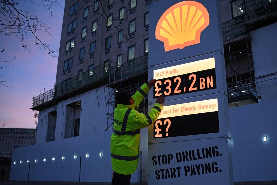 Activist van Greenpeace afficheert de vermoedelijke winst van Shell.