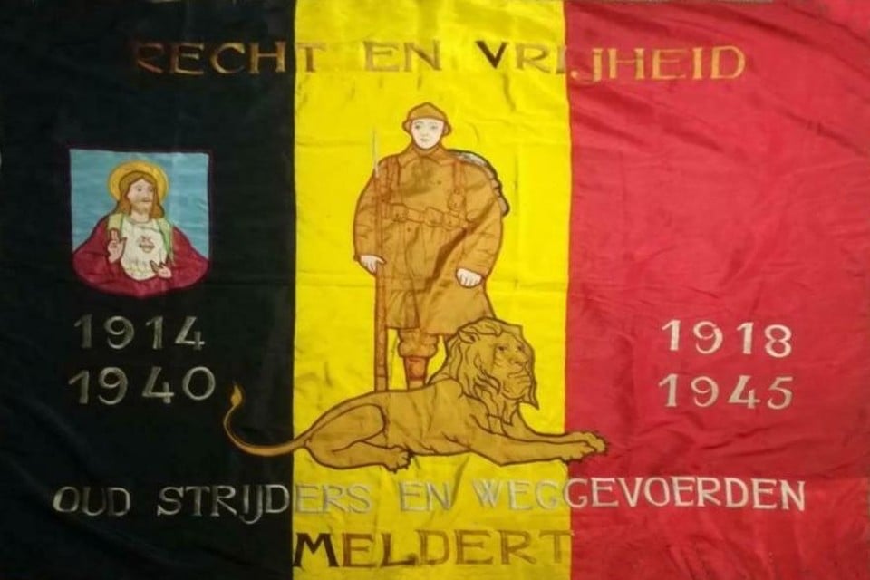 Centraal op de tricolore staat een Belgische soldaat achter een leeuw en links Het H. Hart van Jezus. 