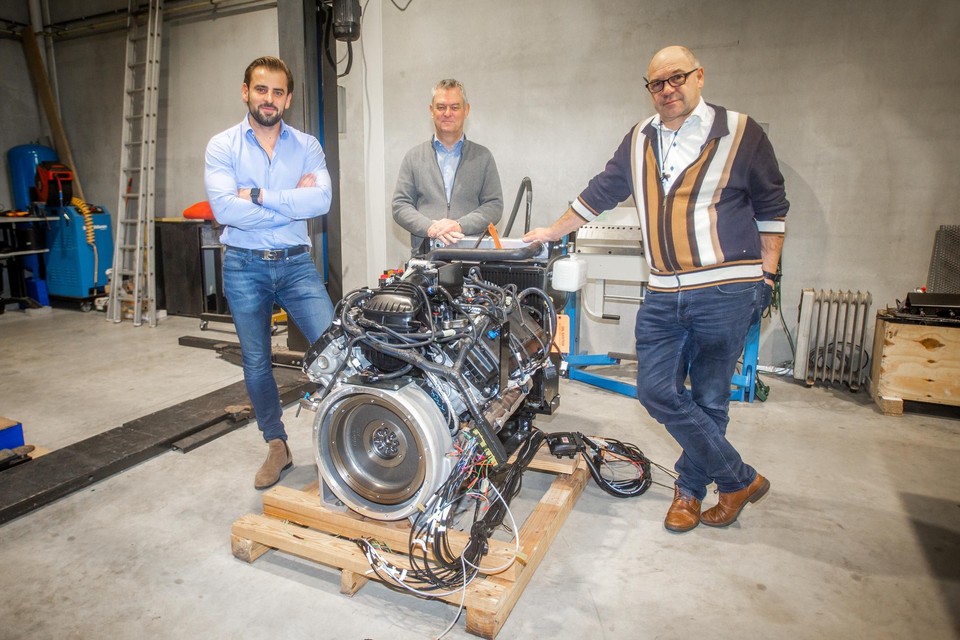 Van links naar rechts Thomas Houben, Peter Van Laer en Mark Pecqueur bij een V8 benzinemotor die omgebouwd wordt voor waterstof. 