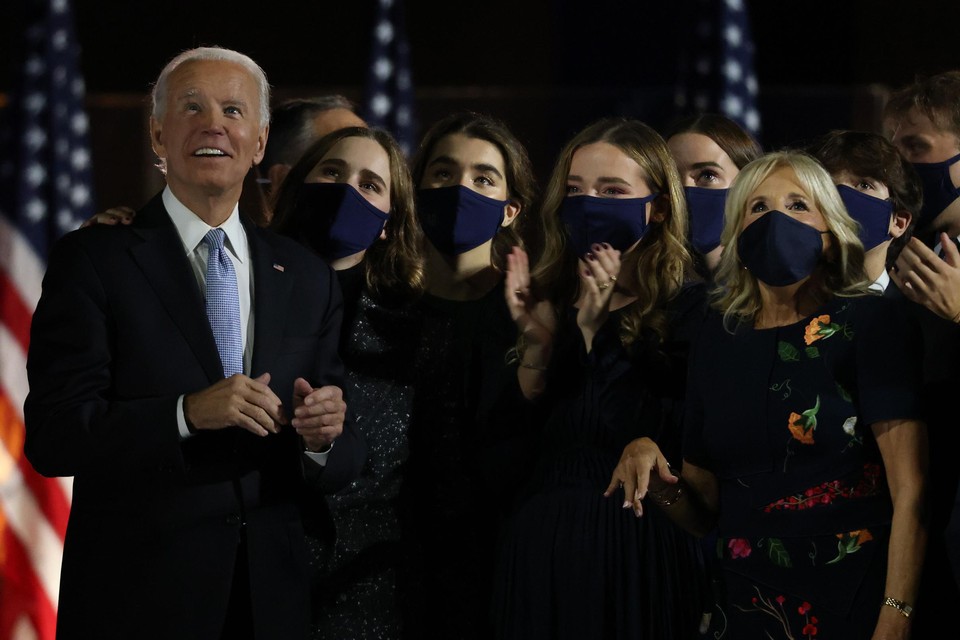 Joe en Jill Biden kijken met hun kleinkinderen naar het vuurwerk, na zijn overwinningsspeech zaterdagnacht in Wilmington, Delaware. 