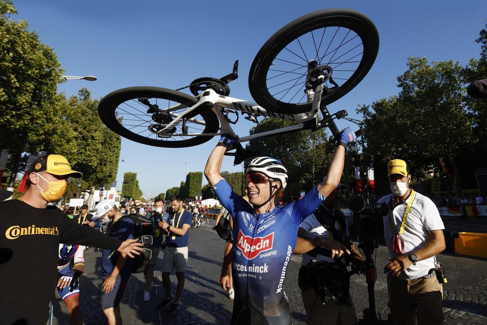 Jasper Philipsen steekt zijn fiets in de Parijse lucht na zijn ritzege op de Champs-Élysées. 