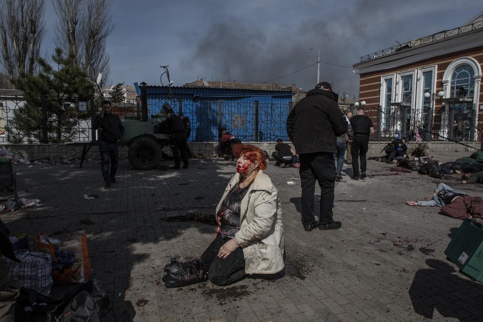 Een gewonde vrouw wacht op hulp, na de dodelijke raketaanval vrijdag op het station van Kramatorsk in de Donetsk-regio. 