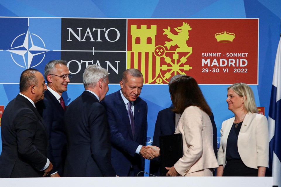 De Turkse president Erdogan schudt de hand van de Zweedse premier en de Finse president op de NAVO-top in Madrid. Secretaris-generaal Jens Stoltenberg kijkt tevreden toe. 