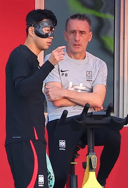 Son (l) en zijn coach Paul Bento bij een training in Qatar. 