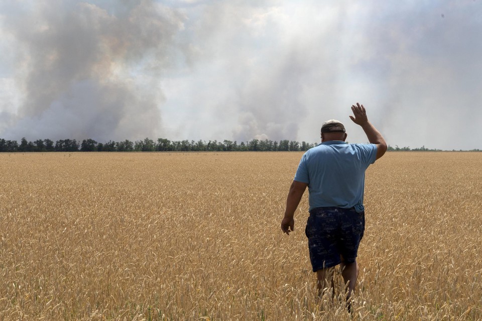 Een Oekraïense graanboer ziet zijn veld branden als gevolg van de Russische invasie. 