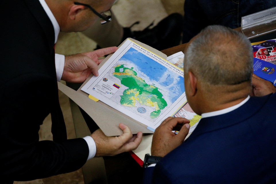 Een Venezolaans parlementslid kijkt naar een kaart met de landsgrenzen.