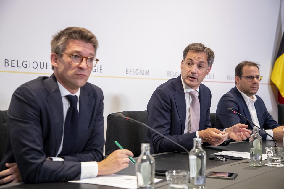 Premier Alexander De Croo (midden, Open Vld) en minister van Werk Pierre-Yves Dermagne (links, PS) tijdens de persconferentie. 