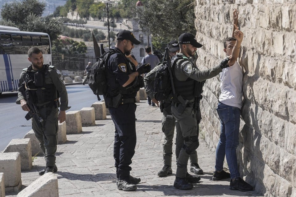 Israëlische veiligheidsdiensten controleren een Palestijnse man buiten de oude stad van Jeruzalem.