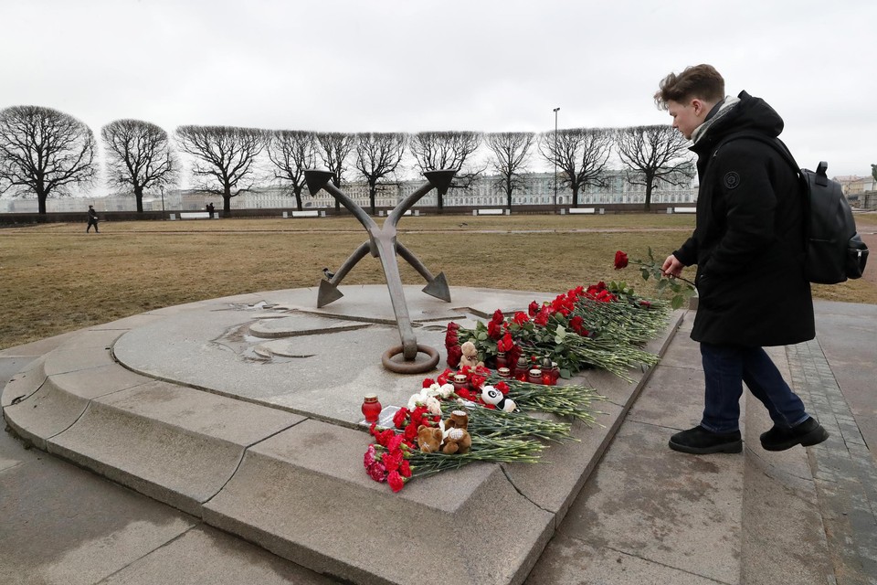 Een Russische burger legt een roos neer op een herdenkingsplek voor de slachtoffers van de aanslag.