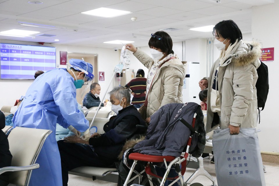 Een covidpatiënte krijgt een medische behandeling in de wachtzaal van een ziekenhuis in Peking. 